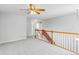 Open loft area featuring plush carpeting, updated lighting, and classic railing at 1526 Braewood Ave, Littleton, CO 80129