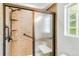 Walk-in shower featuring a glass door, multiple shower heads, and tiled walls at 1526 Braewood Ave, Littleton, CO 80129