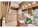 Bathroom with tiled shower-tub, double sink granite vanity, and decorative mirror at 12914 Grant Cir # C, Thornton, CO 80241