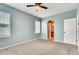 Bedroom featuring neutral walls, carpet flooring, ceiling fan and an arched doorway to the bathroom at 12914 Grant Cir # C, Thornton, CO 80241