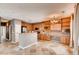Spacious kitchen with island, stainless steel appliances, and wooden cabinets blends seamlessly with the adjacent living area at 12914 Grant Cir # C, Thornton, CO 80241