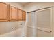 Functional laundry room with washer/dryer hookups, overhead cabinets, and closet space at 12914 Grant Cir # C, Thornton, CO 80241