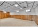 Finished basement with paneled walls, carpeted floor and drop ceiling at 8005 Emerald Ln, Broomfield, CO 80020