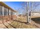 View of the house backyard with a screened in patio and rock landscaping at 4894 Bierstadt Loop, Broomfield, CO 80023