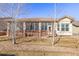 A rear view of the home features a large screened in porch and manicured lawn at 4894 Bierstadt Loop, Broomfield, CO 80023