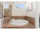 A luxurious soaking tub is surrounded by decorative tile and features a glass enclosed shower at 4894 Bierstadt Loop, Broomfield, CO 80023