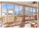 This screened in porch has a wooden floor, ceiling fan, brick supports, and neighborhood views at 4894 Bierstadt Loop, Broomfield, CO 80023