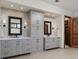 Bathroom featuring double vanities, decorative tile, and storage at 9833 Shoreline Dr, Longmont, CO 80504