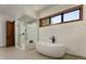 Bathroom featuring a soaking tub, glass shower, and wood trim at 9833 Shoreline Dr, Longmont, CO 80504