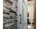Modern bathroom featuring a glass enclosed shower and artistic marble tiled walls at 9833 Shoreline Dr, Longmont, CO 80504