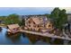 Luxury waterfront home with a private dock, lush landscaping, and stone detailing at 9833 Shoreline Dr, Longmont, CO 80504