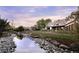 Estate home featuring lush landscaping, a tranquil stream, and picturesque water features at 9833 Shoreline Dr, Longmont, CO 80504
