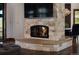 Stone fireplace with hearth and mounted TV, complemented by a dining area view at 9833 Shoreline Dr, Longmont, CO 80504