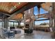 Grand living room features stone walls, fireplace, lake views, spiral staircase, and wood-clad ceiling at 9833 Shoreline Dr, Longmont, CO 80504