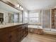 Large bathroom featuring dual sinks, a soaking tub, and a separate tiled shower with a glass door at 3309 Springbriar Dr, Castle Rock, CO 80109