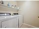 Clean laundry room with white washer and dryer and shelves for organizing laundry supplies at 3309 Springbriar Dr, Castle Rock, CO 80109