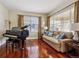 Cozy living room featuring hardwood floors, sofa, piano, and window with lots of natural light at 3309 Springbriar Dr, Castle Rock, CO 80109