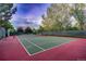 Outdoor tennis court surrounded by mature trees and a green fence at 3462 W 109Th Cir, Westminster, CO 80031