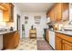 Functional kitchen with wooden cabinets, tile flooring, and essential appliances for everyday cooking at 3130 S Washington St, Englewood, CO 80113