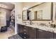 Bathroom featuring double sinks, granite countertops, a large mirror, and access to a walk-in closet at 3477 New Haven Cir, Castle Rock, CO 80109