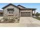 Charming home exterior with stone accents, a two-car garage, and a well-maintained front yard at 3477 New Haven Cir, Castle Rock, CO 80109