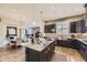 Stylish kitchen features dark cabinets, granite counters, stainless appliances, island, and an open dining area at 3477 New Haven Cir, Castle Rock, CO 80109