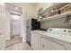 Well-organized laundry room with modern appliances, storage shelves, and tile flooring at 3477 New Haven Cir, Castle Rock, CO 80109