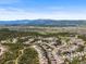 Aerial view of a neighborhood with mountain views and sprawling trees, offering a blend of suburban and natural beauty at 16312 Morning Rise Ln, Monument, CO 80132