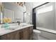 Bathroom with vanity, marble countertop, hexagon tile, framed mirror, and shower at 16312 Morning Rise Ln, Monument, CO 80132