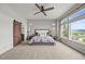 Bright bedroom boasts scenic views, a ceiling fan, and barn door leading to the ensuite bathroom at 16312 Morning Rise Ln, Monument, CO 80132