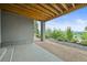 Outdoor patio with exposed wood beams, concrete floor and gravel landscaping at 16312 Morning Rise Ln, Monument, CO 80132