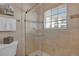 Updated tiled bathroom with a glass-enclosed shower and window bringing in natural light at 3866 S Dallas Cir # 201, Aurora, CO 80014