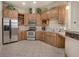 Charming kitchen with stainless steel appliances, light tile floors, and natural wood cabinetry at 3866 S Dallas Cir # 201, Aurora, CO 80014