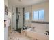 Luxurious bathroom with a soaking tub, walk-in shower, and elegant marble flooring at 7746 S Valdai Ct, Aurora, CO 80016
