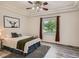 Bedroom with hardwood floors, stylish ceiling fan and natural light streaming through a large window at 7746 S Valdai Ct, Aurora, CO 80016