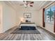 Relaxing bedroom featuring stylish floors, a tray ceiling with a ceiling fan and a cozy decorative rug at 7746 S Valdai Ct, Aurora, CO 80016