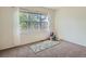 Bedroom featuring carpeted floors, a large window providing natural light, and a yoga mat at 7746 S Valdai Ct, Aurora, CO 80016