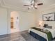 Bedroom view showing hardwood floors, a ceiling fan, decor, and an ensuite bathroom with walk-in closet at 7746 S Valdai Ct, Aurora, CO 80016