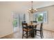 Bright breakfast nook featuring a round table, stylish chandelier, and a sliding door with a view of the yard at 7746 S Valdai Ct, Aurora, CO 80016