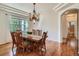 Elegant dining room with hardwood floors and a chandelier fixture, adjacent to bathroom access at 7746 S Valdai Ct, Aurora, CO 80016