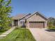 Charming home with a brick facade, well-manicured lawn, and a two-car garage on a sunny day at 7746 S Valdai Ct, Aurora, CO 80016