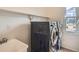Efficient laundry room with new washer and dryer, window and storage shelf above utility sink at 7746 S Valdai Ct, Aurora, CO 80016