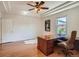Bright office space boasting hardwood floors, a large desk, and tray ceilings with a stylish ceiling fan at 7746 S Valdai Ct, Aurora, CO 80016