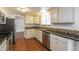 Bright kitchen with white cabinetry, stainless steel appliances, and decorative backsplash at 17209 E Evans Dr, Aurora, CO 80013