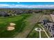 Scenic aerial view of a residential area adjacent to a green golf course at 16544 E 118Th Dr, Commerce City, CO 80022