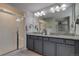 Dual sink bathroom featuring granite counters, gray cabinets, and glass-enclosed shower at 16544 E 118Th Dr, Commerce City, CO 80022