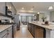 Modern kitchen with stainless steel appliances and granite counter flowing to living area at 16544 E 118Th Dr, Commerce City, CO 80022