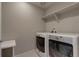 A conveniently located laundry room with modern appliances and overhead shelving at 16544 E 118Th Dr, Commerce City, CO 80022