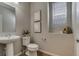 Well-lit powder room featuring a pedestal sink, toilet, and decorative accents at 16544 E 118Th Dr, Commerce City, CO 80022