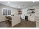 Basement bar with white cabinets, floating shelves, marble backsplash, and a waterfall island at 9443 Torrey Way, Arvada, CO 80007